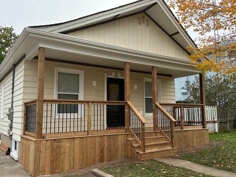 Cream horizontal siding with new porch soffit and fascia on a bungalow